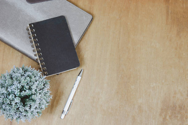istock Top view flat lay notebook and flower and pen on wood table.Copy space 1368491624
