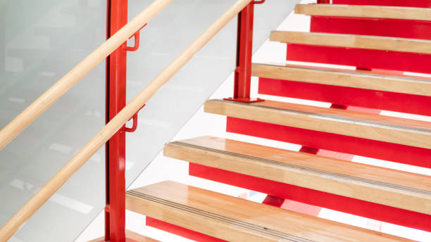 istock Wooden stair step ladder on red steel staircase structure 1368495274