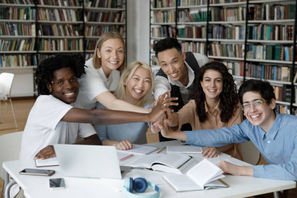 istock Mixed race team of happy students giving group high five 1368496795