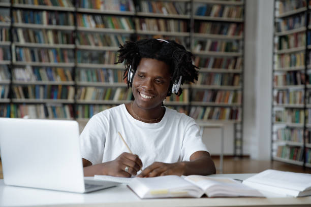 istock Cheerful student guy enjoying studying in college library 1368496854
