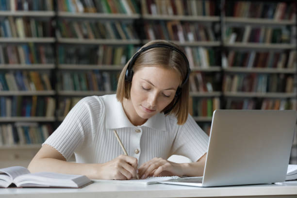 istock Serious student girl listening to audio tutorials from wireless headphones, 1368496862