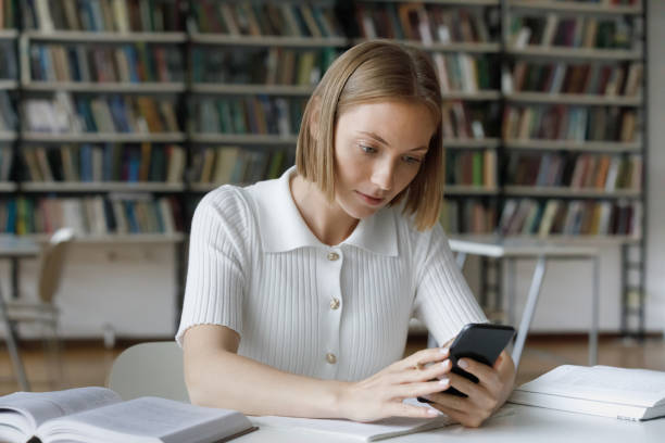 istock Focused serious female student using online app on mobile phone 1368496868