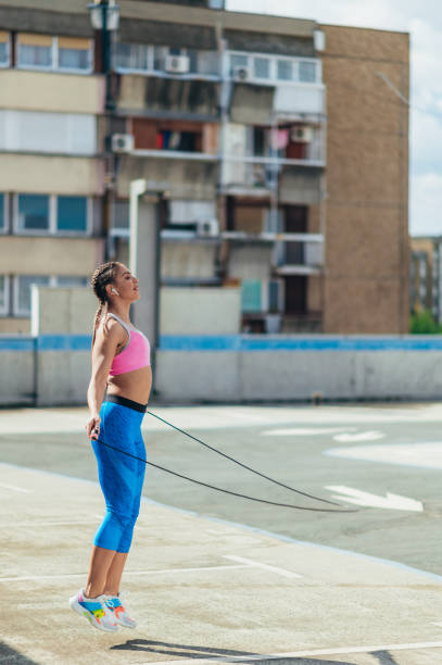 istock Attractive young woman using a fitness jump rope while training outside 1368498169