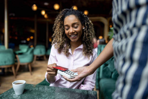 istock Woman paying by card at a restaurant making a contactless payment 1368500052