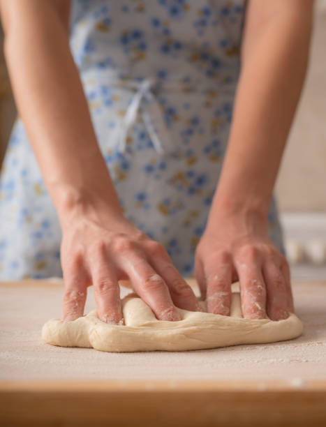 istock Female hands knead dough for pizza. Domestic Italian kitchen. Selective focus. 1368509680