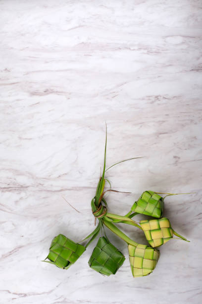 ketupat ou boulette de riz est une délicatesse locale pendant la saison des fêtes. ketupats, un boyau de riz naturel fabriqué à partir de jeunes feuilles de cocotier - casing photos et images de collection