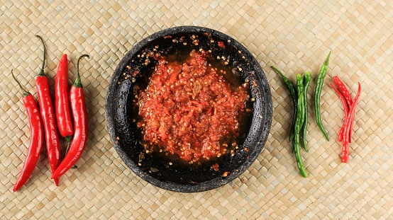 Chilli Paste or Sambal, Top View with Red Chilli Pepper on Woven mat. Concept Spicy Food