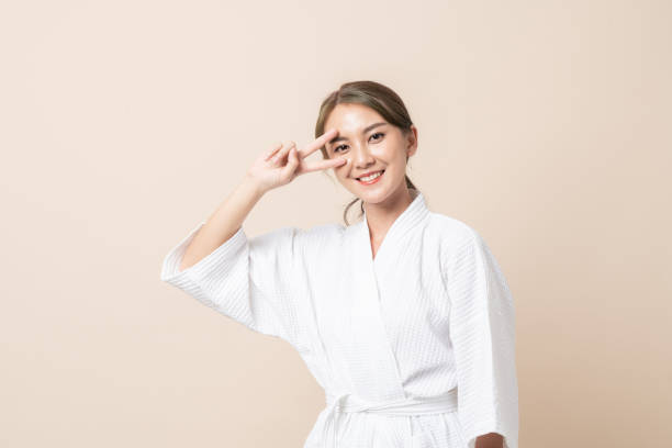 istock Portrait Asian women in bathrobe on brown isolated studio background. 1368514751