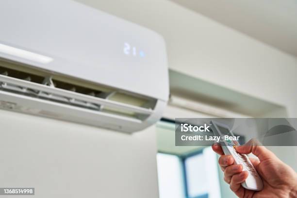 Hand Adjusting Temperature On Air Conditioner Stock Photo - Download Image Now - Air Conditioner, Torn, Heat - Temperature
