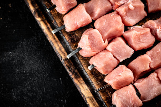 istock Pork kebab raw on a wooden cutting board. 1368520169