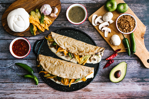 Mexican chicharrón quesadilla with oaxaca cheese and squash blossom, traditional food from the city of Puebla in Mexico