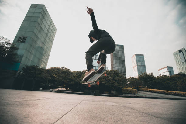 Skateboarder skateboarding outdoors in city stock photo