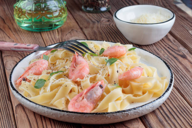 istock Pasta fettuccine with shrimp in rustic plate with fork 1368530008