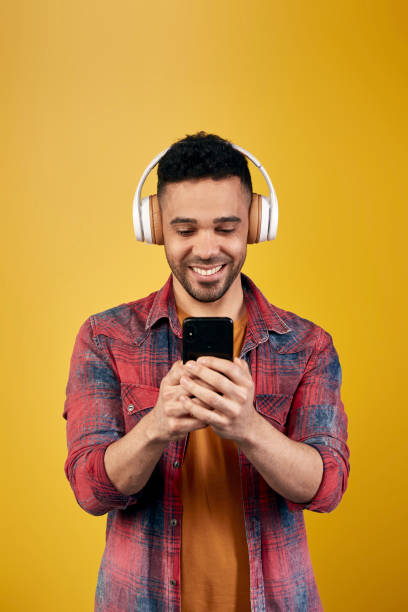 istock Content ethnic man in headphones browsing smartphone 1368532334