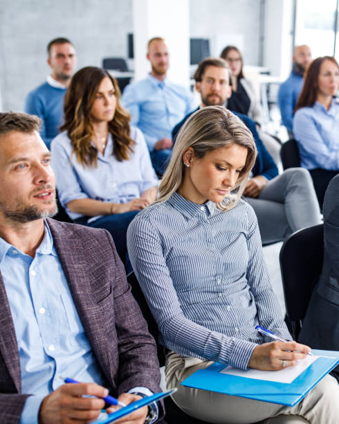 grande gruppo di imprenditori che prendono appunti su un seminario nella sala del consiglio. - business seminar writing women foto e immagini stock