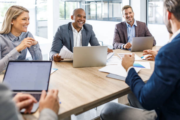 istock Happy business colleagues talking while working in the office. 1368536764