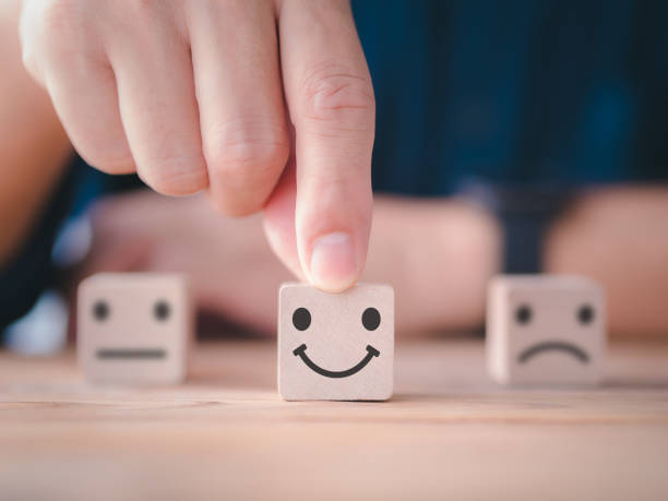 istock Customer satisfaction survey concept. Close up customer hand choose happy smiley face, blurred neutral and sad face icon on wood cube to survey feedback, rating, review, service satisfaction. 1368543080