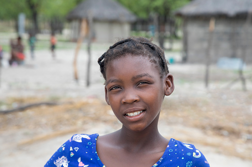 happy young african village girl in front of her house