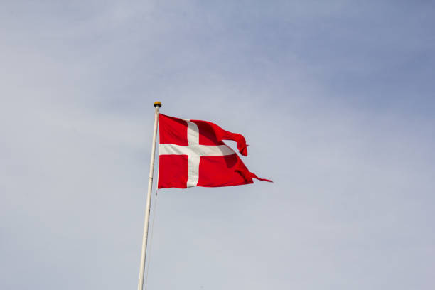 istock Red and white Danish flag waving in strong wind 1368543640