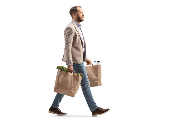 istock Man walking and carrying two grocery bags 1368545071
