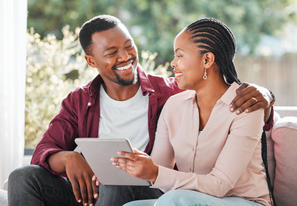 istock Shot of a young couple relaxing at home using a digital tablet 1368545880