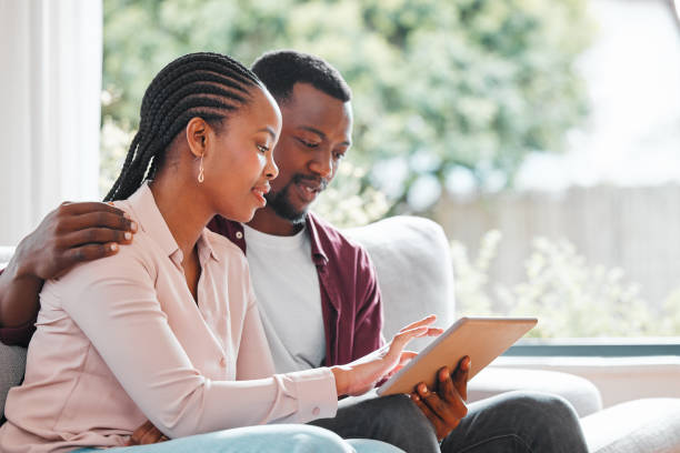 istock Shot of a young couple relaxing at home using a digital tablet 1368545886