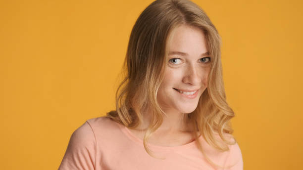 istock Pretty cute girl charmingly looking in camera isolated on yellow 1368546070