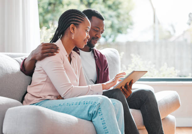istock Shot of a young couple relaxing at home using a digital tablet 1368546116