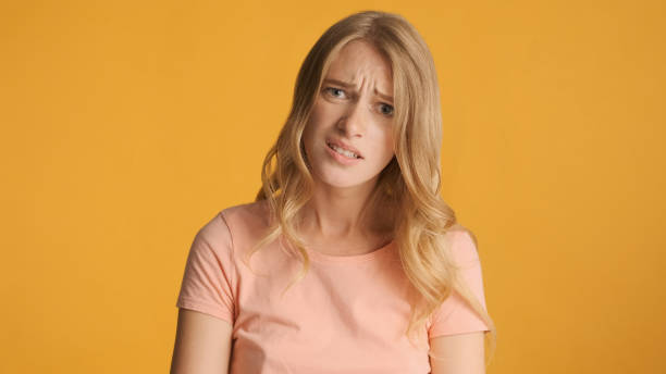 istock Sad girl with frowning face posing on camera over yellow backgro 1368546152