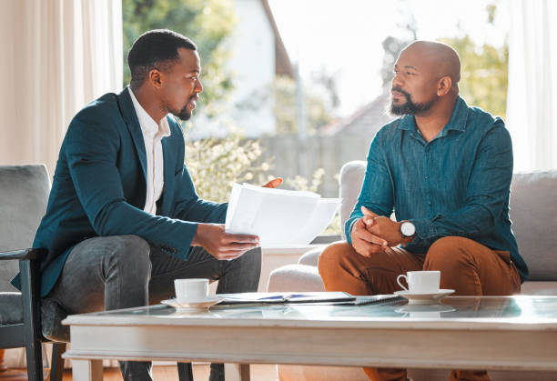 Shot of a mature man having a meeting with a finance broker How much longer will this meeting be pointer stock pictures, royalty-free photos & images