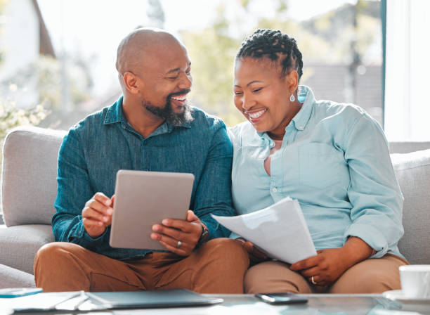 scatto di una coppia matura che usa un tablet digitale insieme - retirement senior adult finance couple foto e immagini stock