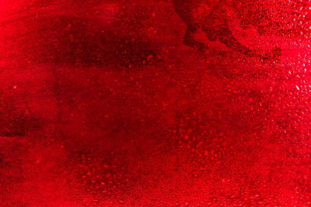 istock Glass with water drops on red background. 1368549990