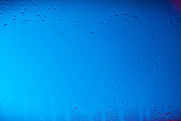 Texture created in a glass with water drops on colorful background.