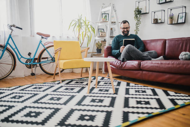 istock Shot of a man using his tablet while relaxing on the couch at home 1368550741