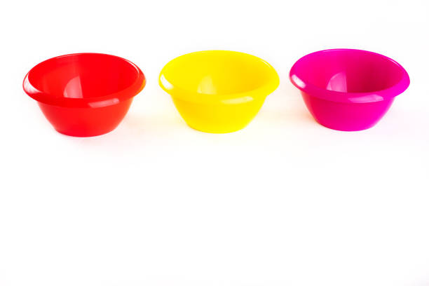 Plastic round bowls of different colors on a white background. kitchen containers for dry ingredients. Bowls for Montessori games. sorting capacities. Isolate. Copy space, top view