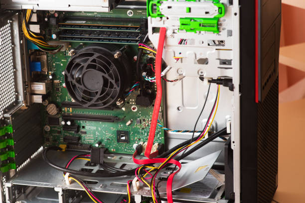 istock Wizard repairs personal computer with tools and hands. Disassembly of the computer into spare parts 1368551280