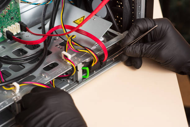 istock Wizard repairs personal computer with tools and hands. Disassembly of the computer into spare parts 1368551284