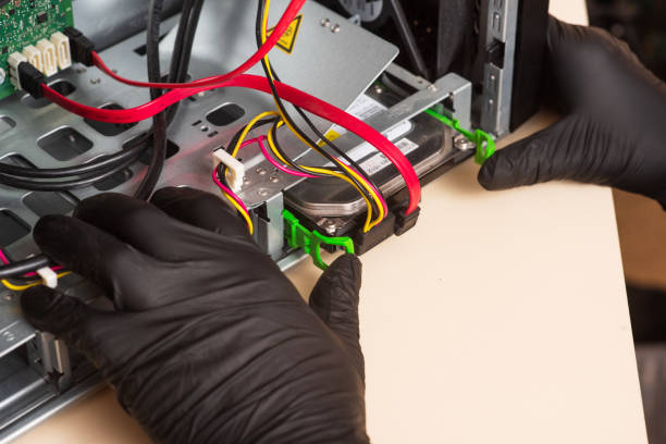 istock Wizard repairs personal computer with tools and hands. Disassembly of the computer into spare parts 1368551299