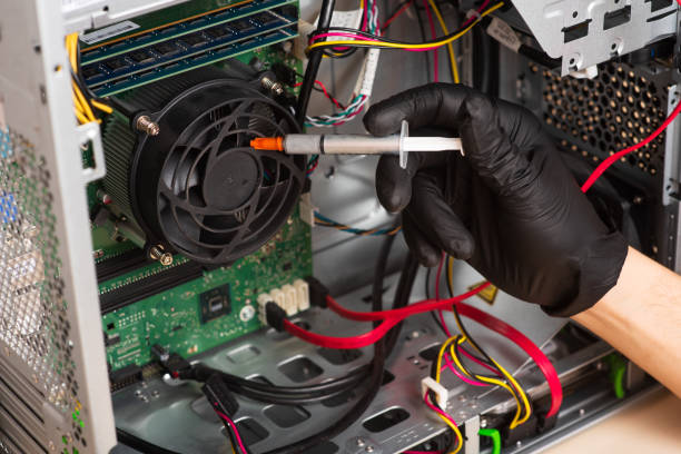 istock Wizard repairs personal computer with tools and hands. Disassembly of the computer into spare parts 1368551302