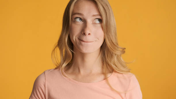 istock Cute girl slyly thinking about something on camera over colorful 1368552756