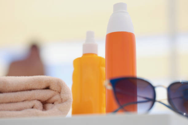 Orange flip flops and sun cream, isolated on white with clipping path.