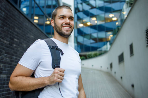 istock Cheerful man holding a backpack and smiling 1368556177