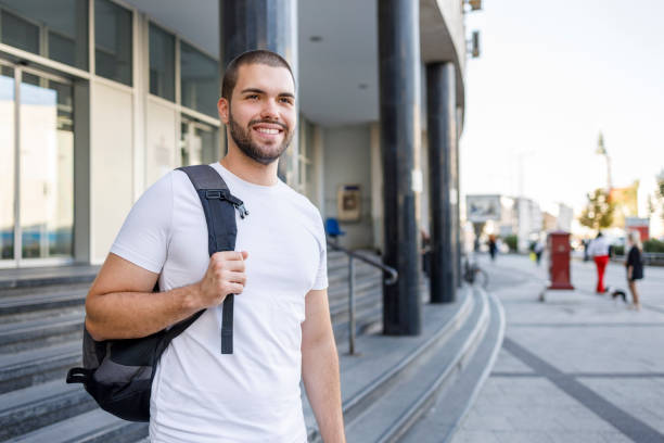 istock Cheerful male student wearing a backpack and smiling 1368556181