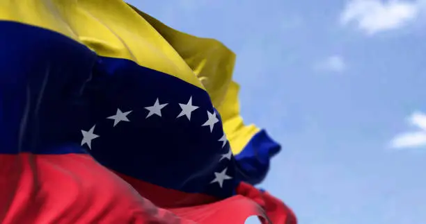 Photo of Detail of the national flag of Venezuela waving in the wind on a clear day