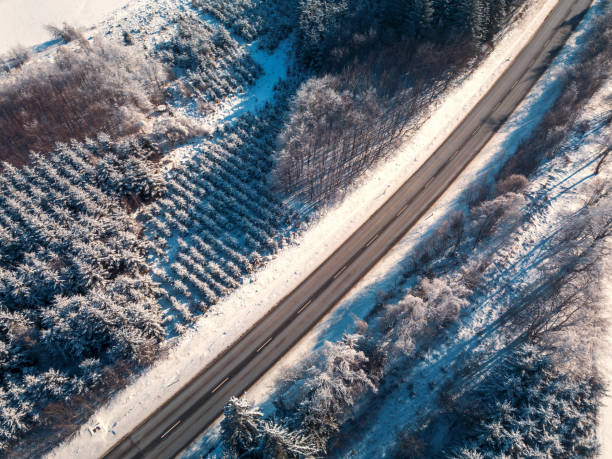 вид с воздуха на зимнюю дорогу, в солнечный день - winterroad стоковые фото и изображения