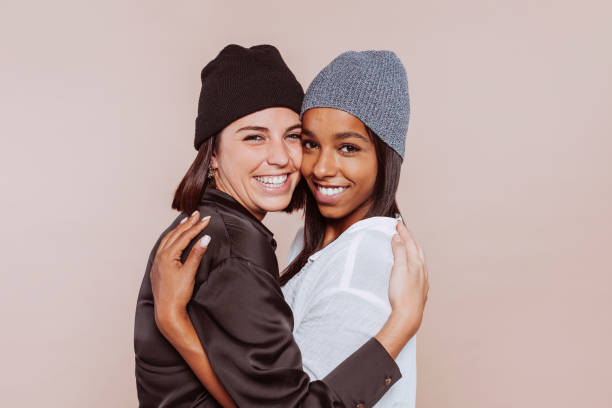 istock Two women embrace and smile positively at studio 1368558921