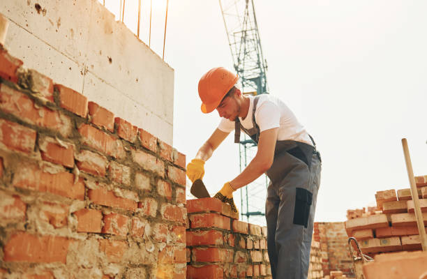 istock Young construction worker in uniform is busy at the unfinished building 1368559093