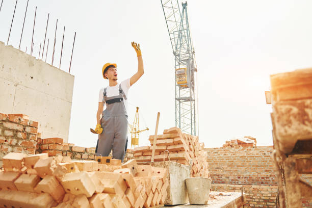 istock Young construction worker in uniform is busy at the unfinished building 1368559135