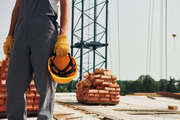 istock Close up view. Young construction worker in uniform is busy at the unfinished building 1368559252