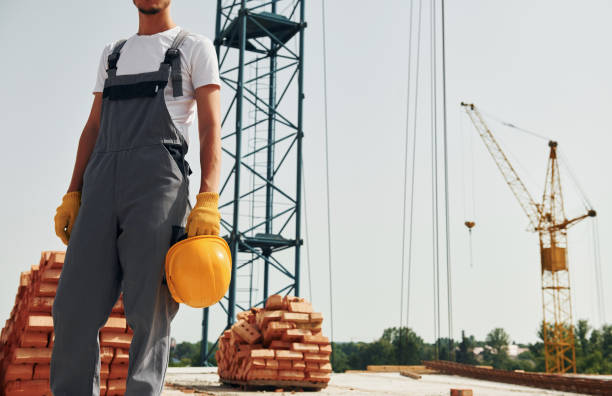 istock Close up view. Young construction worker in uniform is busy at the unfinished building 1368559253